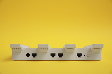 Photo of Modern Wi-Fi router on yellow background. Space for text