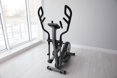 Photo of Elliptical machine cross trainer near window indoors