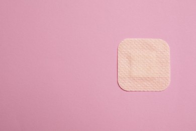 Contraceptive patch on pink background, top view. Space for text