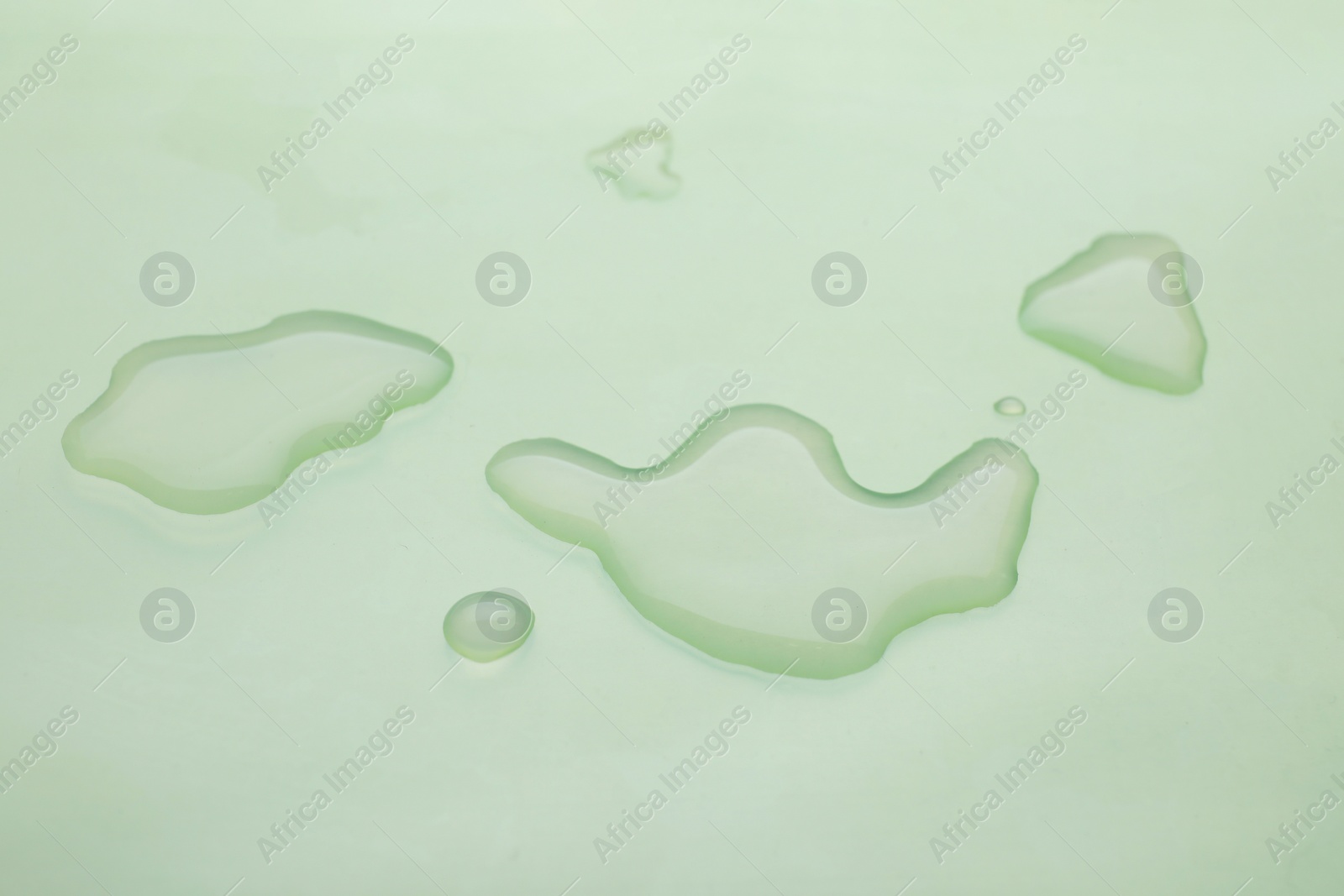 Photo of Puddle of water on light green background