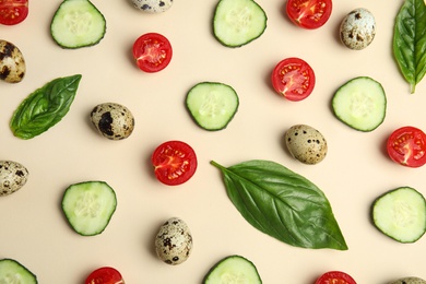 Photo of Fresh vegetables and quail eggs on beige background, flat lay