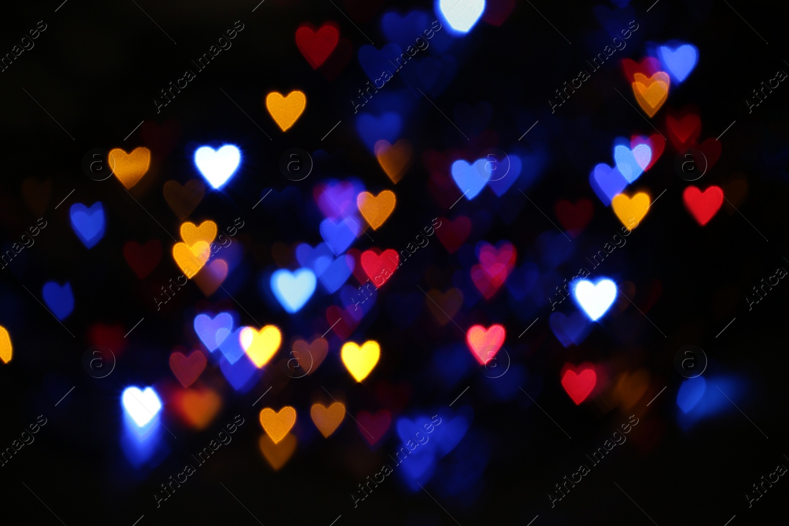 Photo of Blurred view of colorful heart shaped lights on black background