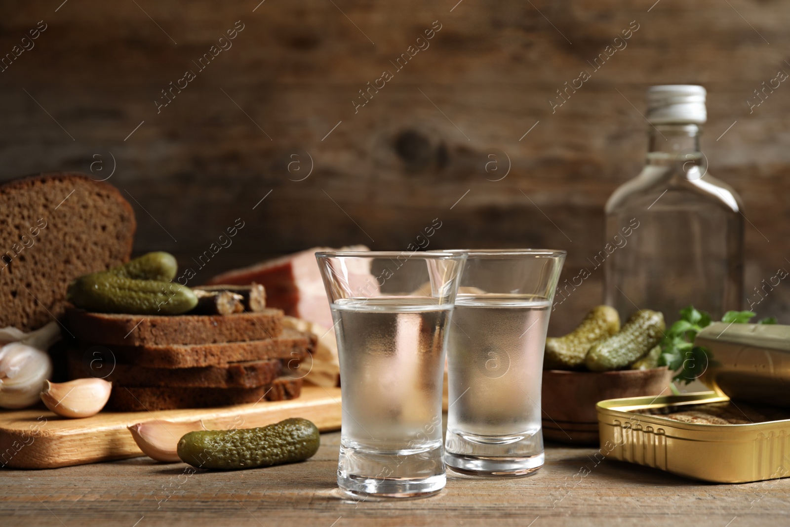 Photo of Cold Russian vodka with snacks on wooden table