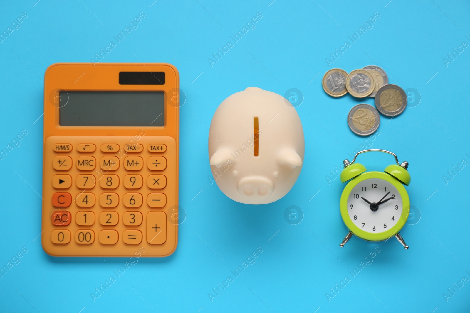 Photo of Piggy bank, alarm clock, calculator and coins on light blue background, flat lay