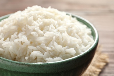 Photo of Bowl of tasty cooked white rice on table, closeup