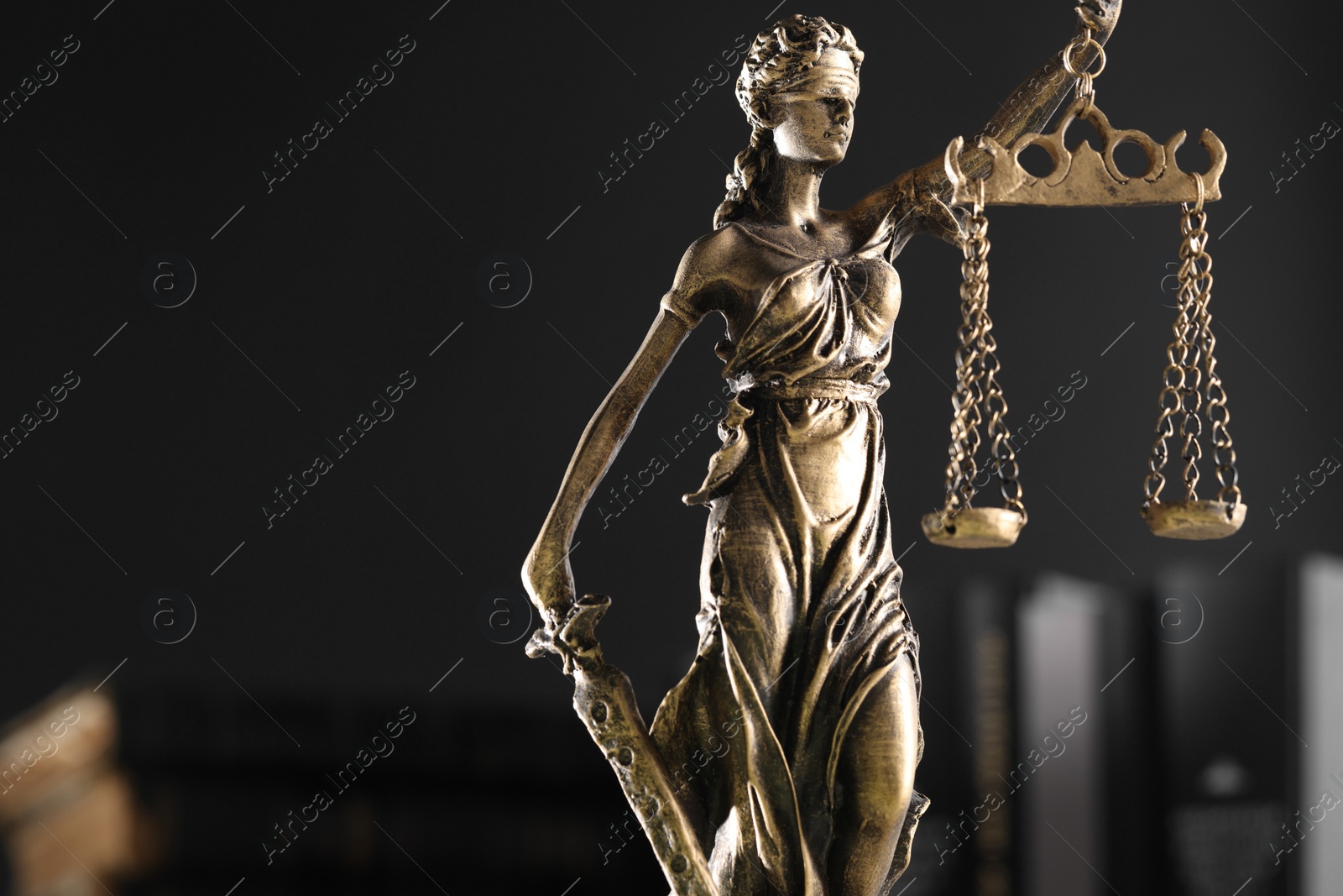 Photo of Symbol of fair treatment under law. Statue of Lady Justice on dark background, space for text