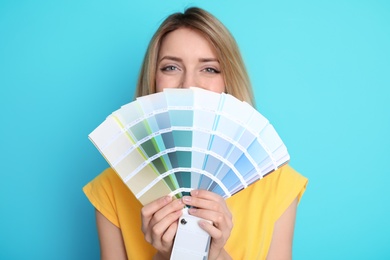 Young woman with palette on color background