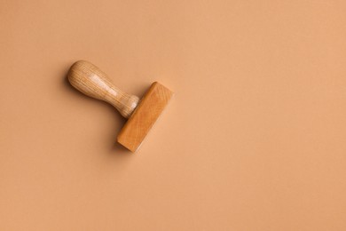 Photo of One wooden stamp tool on light brown background, top view. Space for text