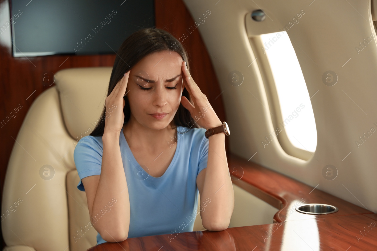 Photo of Young woman feeling bad during flight in airplane