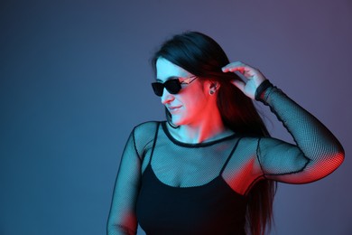 Portrait of beautiful young woman with sunglasses on color background. Space for text