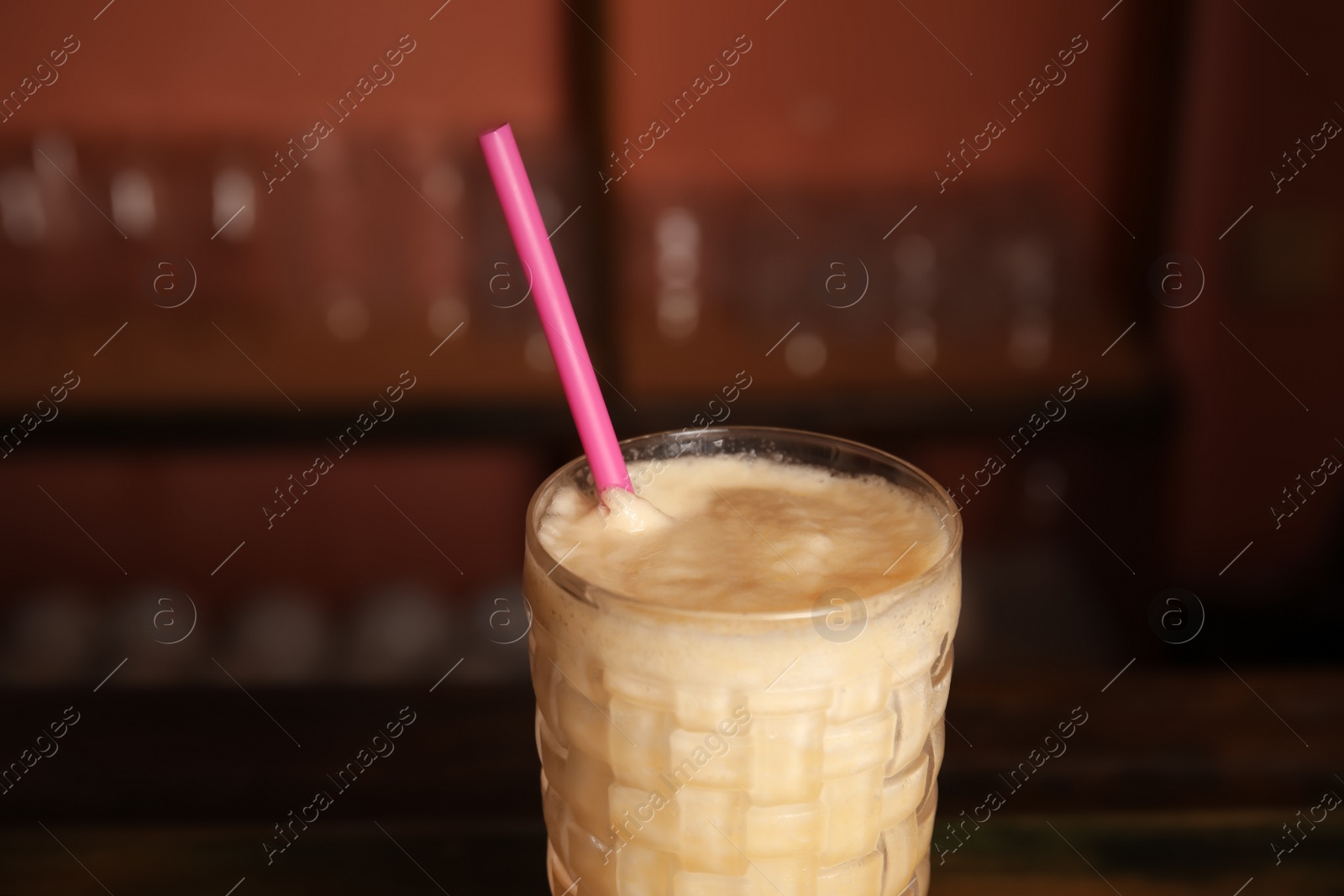 Photo of Glass with delicious cocktail on blurred background, closeup