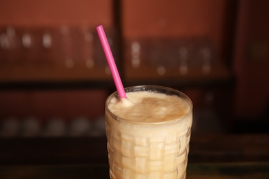 Photo of Glass with delicious cocktail on blurred background, closeup