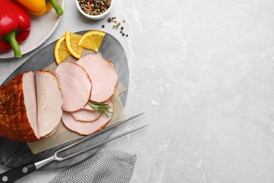 Photo of Delicious sliced ham with orange and rosemary on grey marble table, flat lay. Space for text