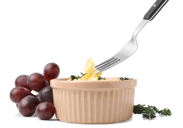 Photo of Taking tasty baked camembert with fork from bowl on white background