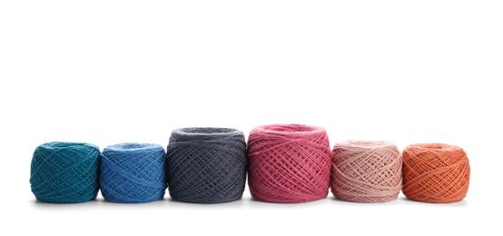 Photo of Clews of colorful knitting threads in row on white background