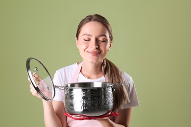 Photo of Happy woman with pot on olive background