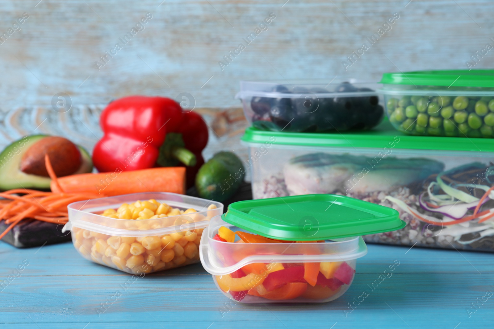 Photo of Set of plastic containers with fresh food on light blue wooden table