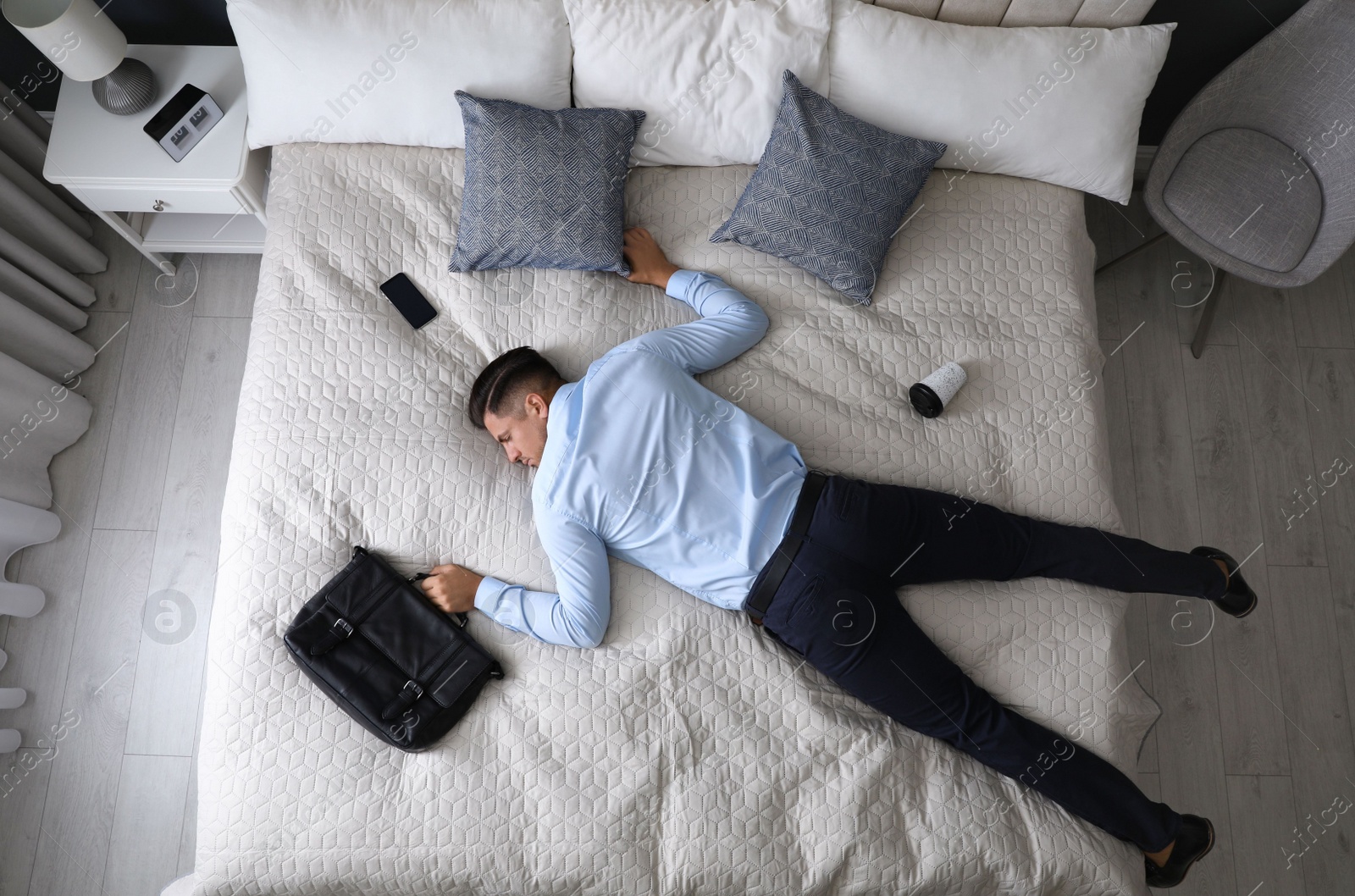 Photo of Exhausted businessman in office wear sleeping on bed at home after work, above view