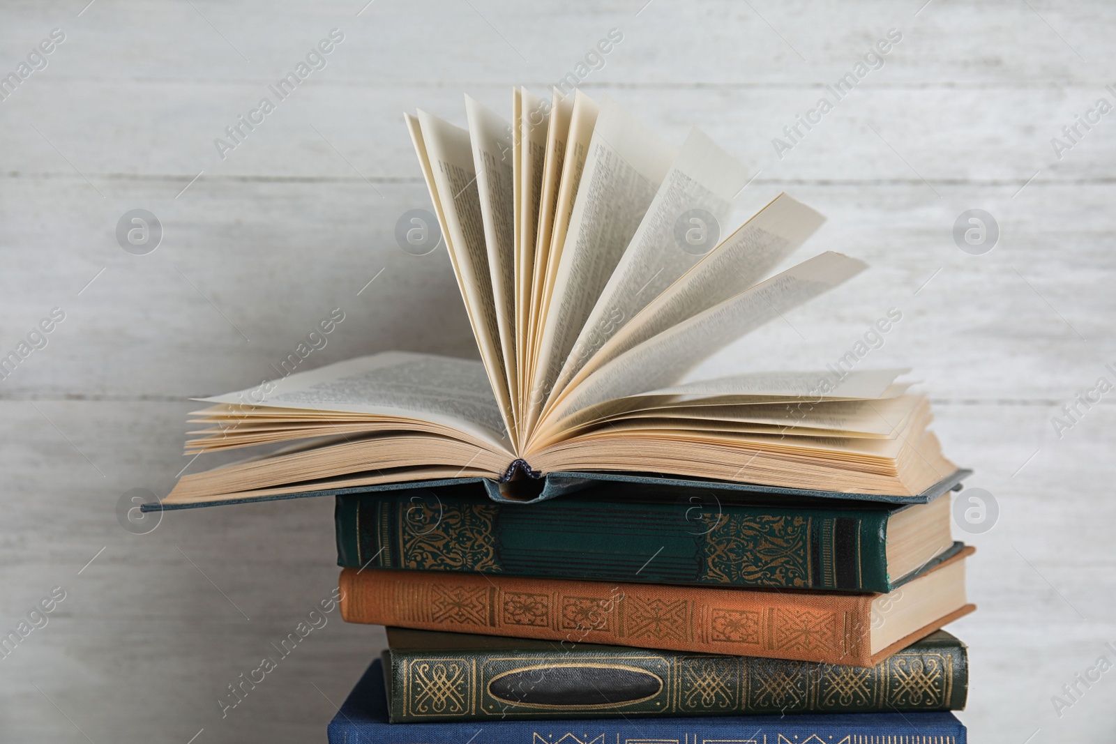 Photo of Stack of hardcover books on white wooden background