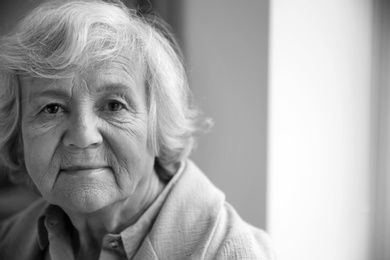 Photo of Portrait of elderly woman indoors, space for text. Black and white effect