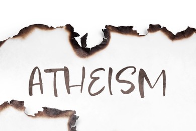 Image of Word Atheism on paper with burnt borders. Philosophical or religious position