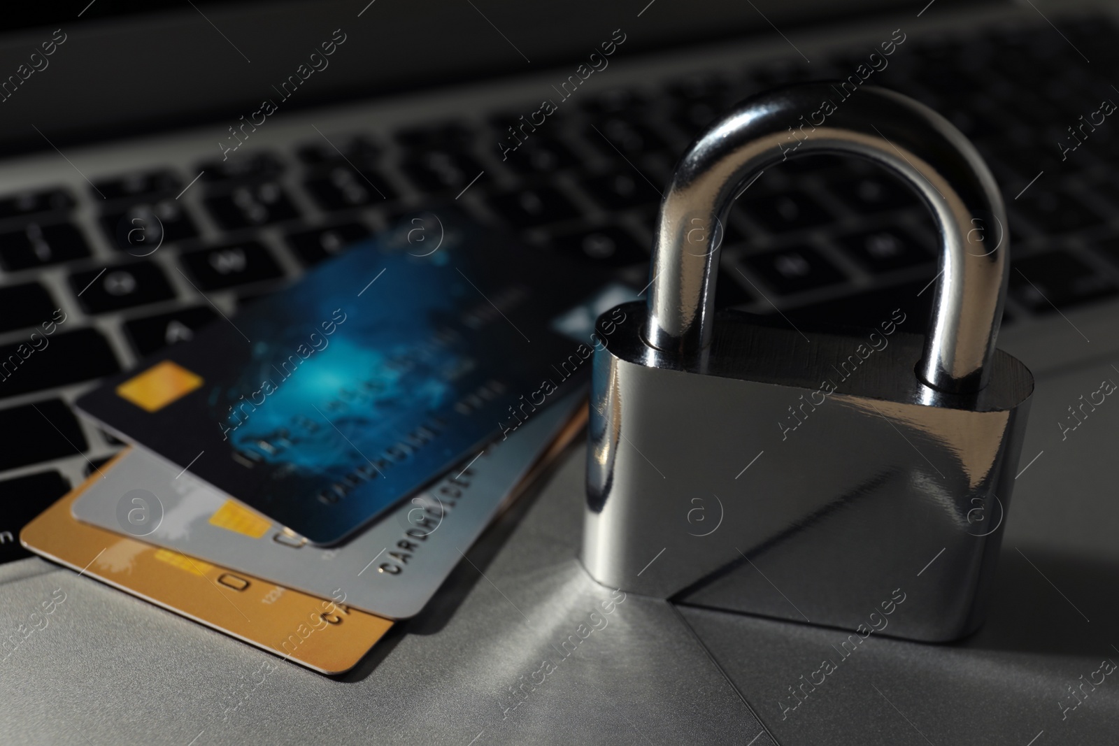 Photo of Credit cards and lock on laptop, closeup. Cyber crime