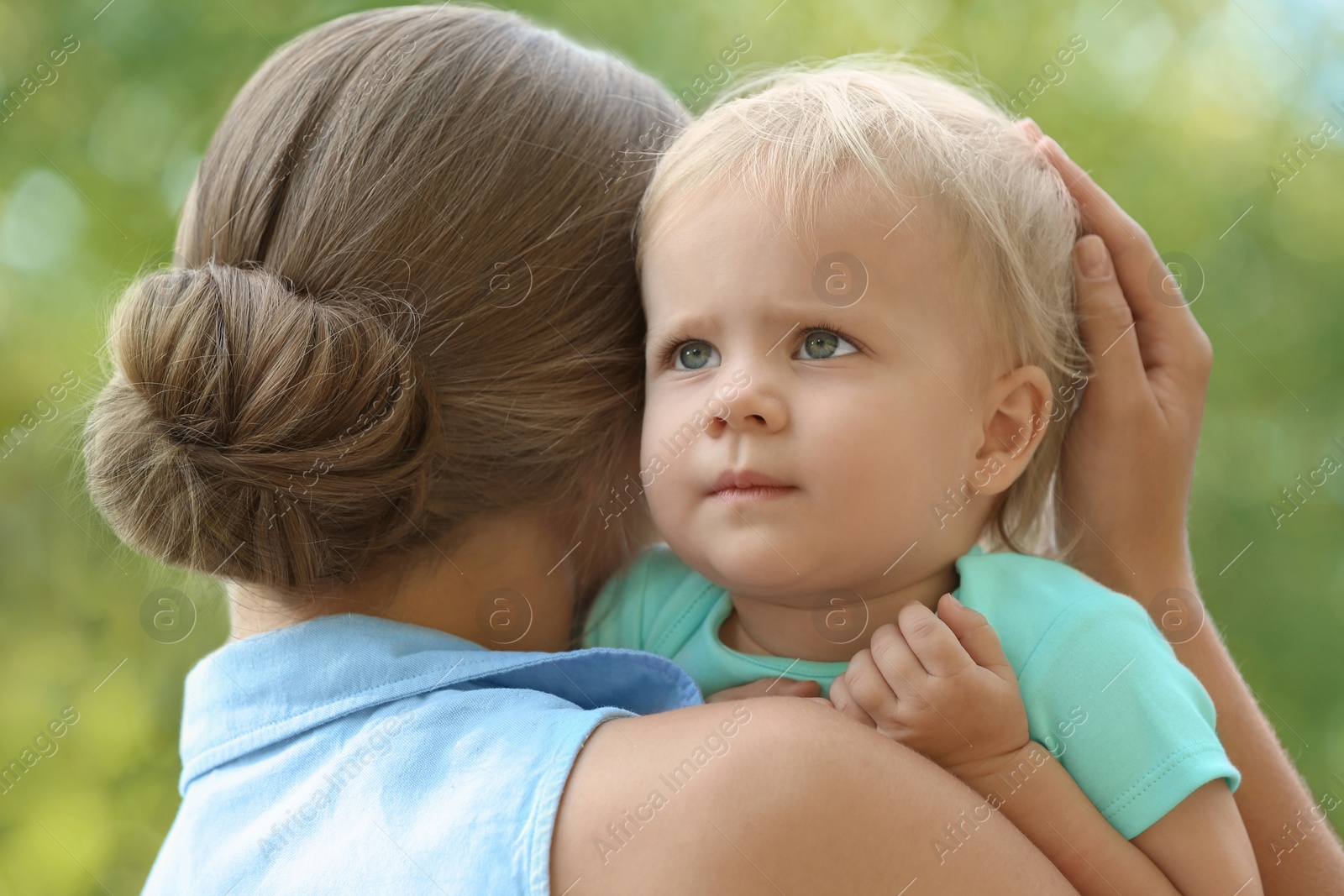 Photo of Young mother with her cute child in green park