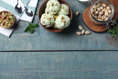 Photo of Delicious pistachio ice cream served on blue wooden table, flat lay. Space for text