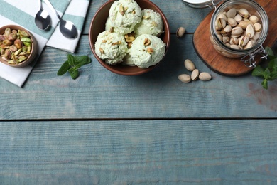 Delicious pistachio ice cream served on blue wooden table, flat lay. Space for text