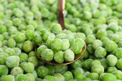 Photo of Frozen peas and spoon, closeup. Vegetable preservation