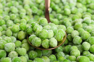 Frozen peas and spoon, closeup. Vegetable preservation