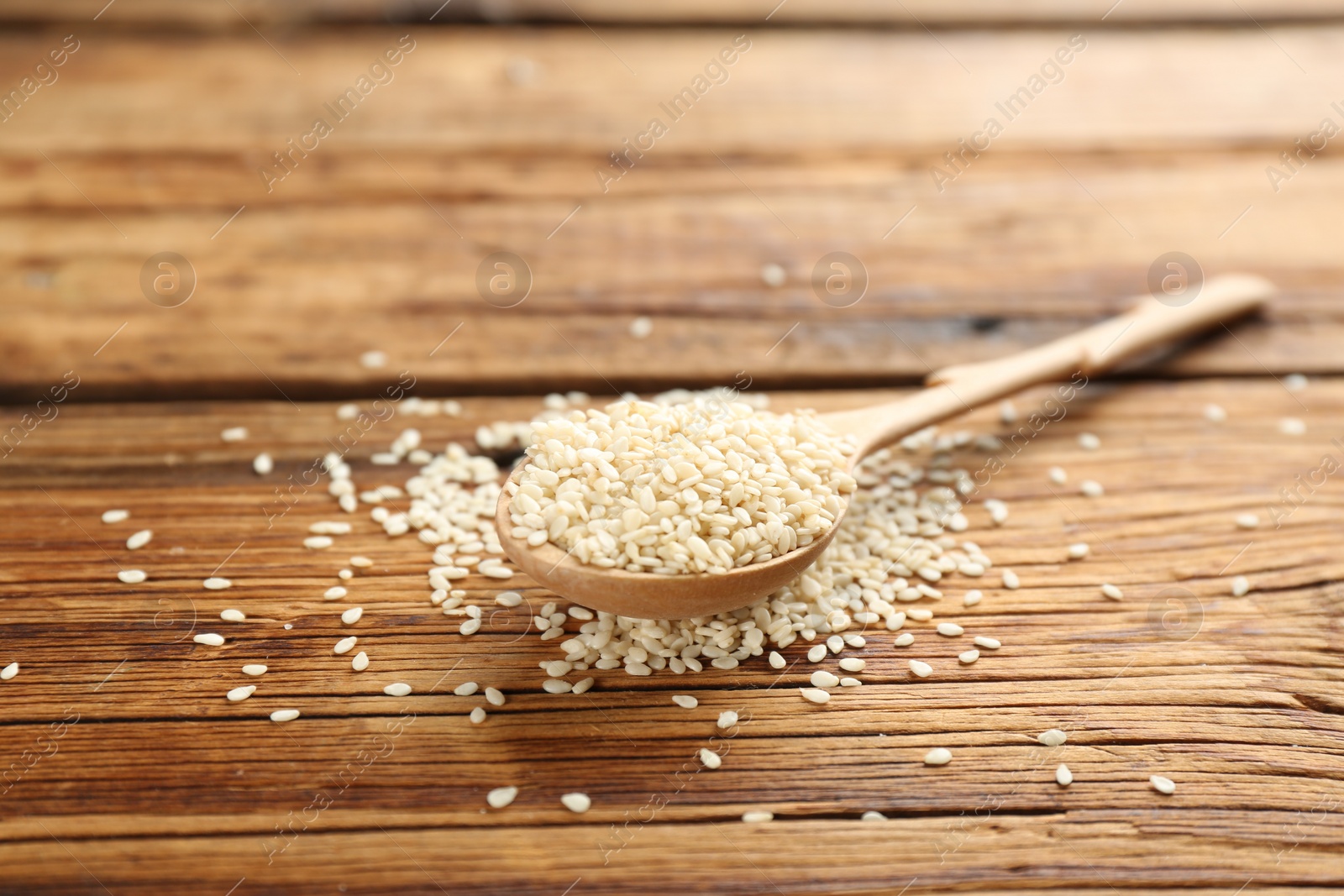 Photo of White sesame seeds on wooden table, closeup