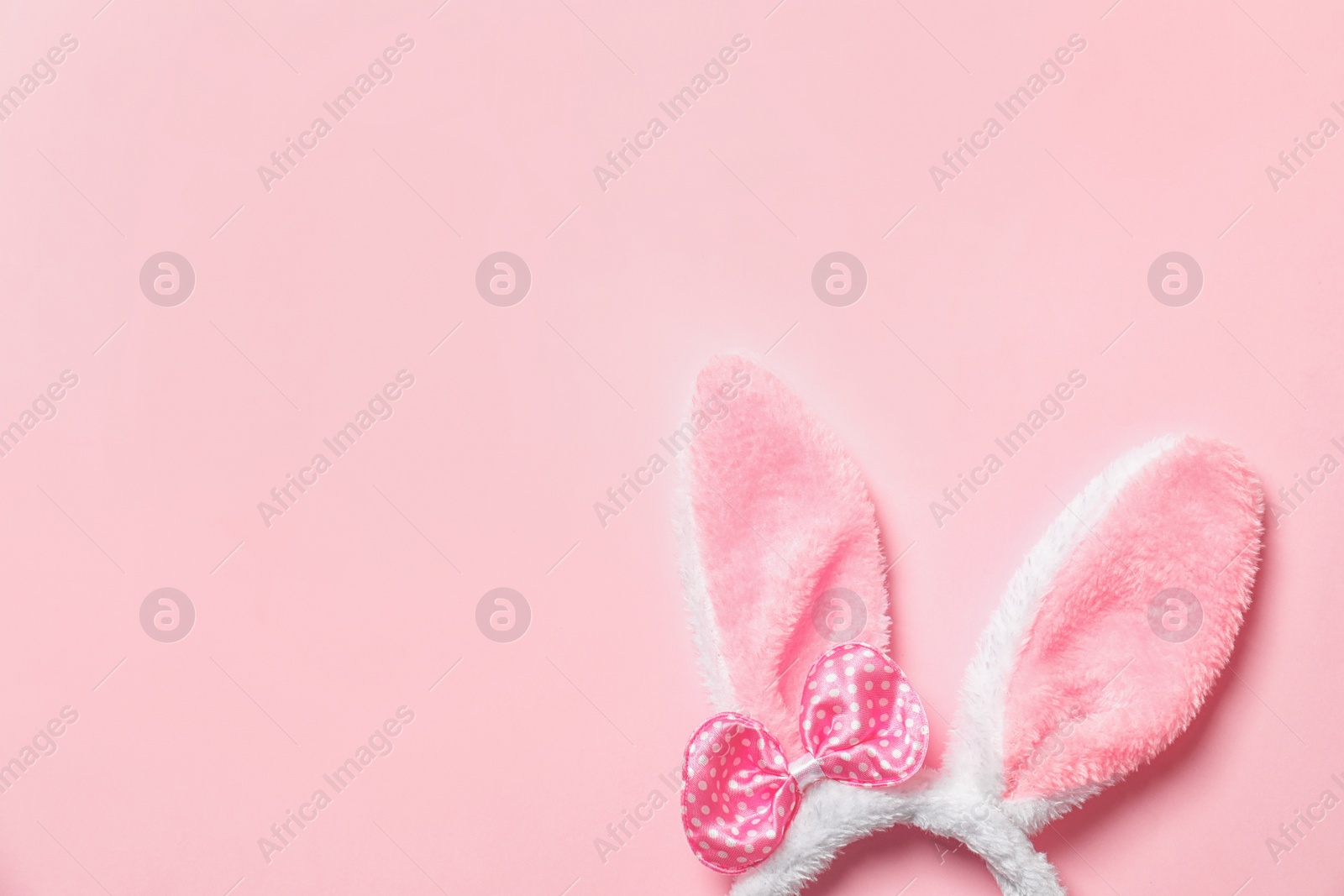 Photo of Funny headband with Easter bunny ears on color background, top view. Space for text