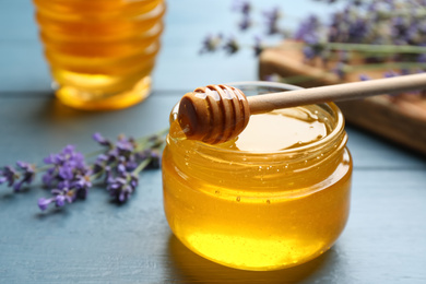Photo of Fresh honey in jar on blue wooden table