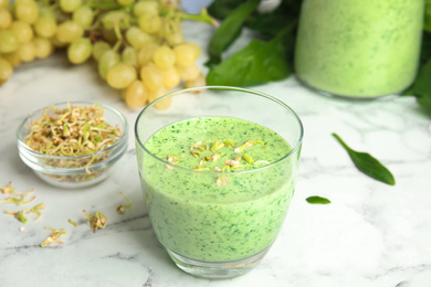 Photo of Green buckwheat smoothie on white marble table