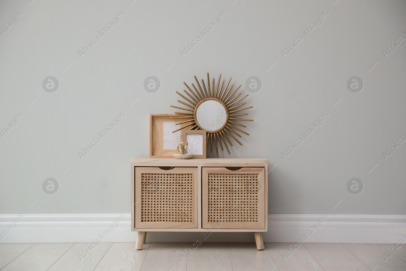 Photo of Stylish room interior with wooden cabinet near grey wall