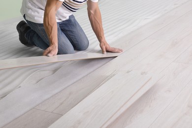 Man installing new laminate flooring indoors, closeup