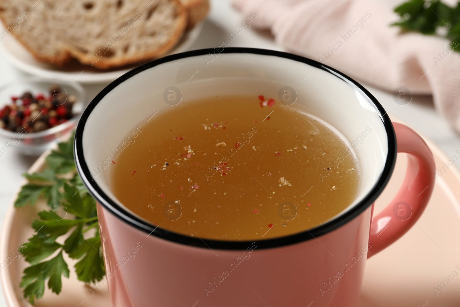 Photo of Hot delicious bouillon in cup on table, closeup