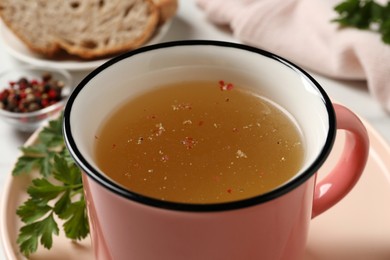 Hot delicious bouillon in cup on table, closeup