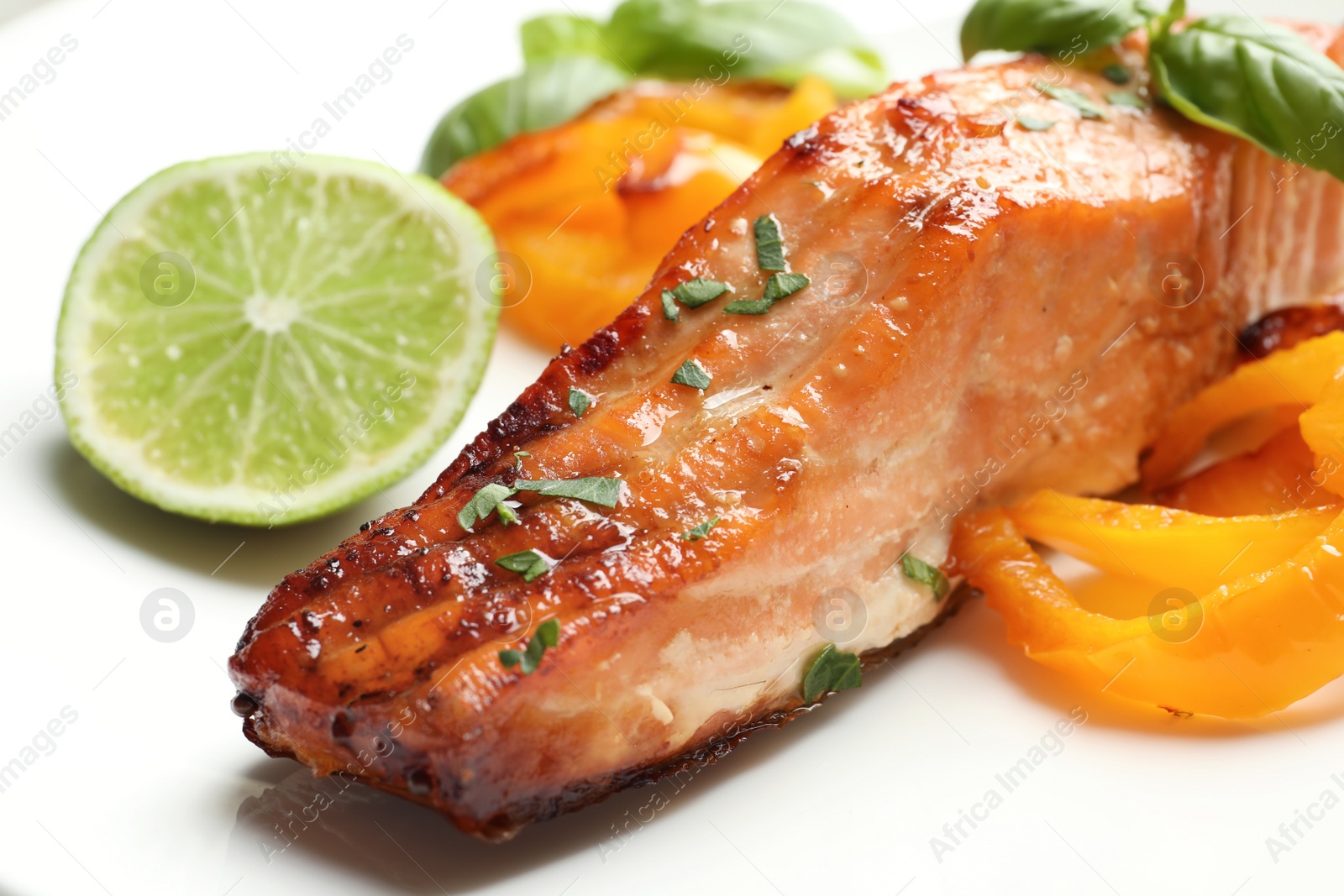 Photo of Tasty grilled salmon with vegetables, closeup