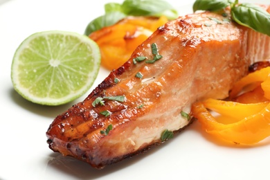 Photo of Tasty grilled salmon with vegetables, closeup