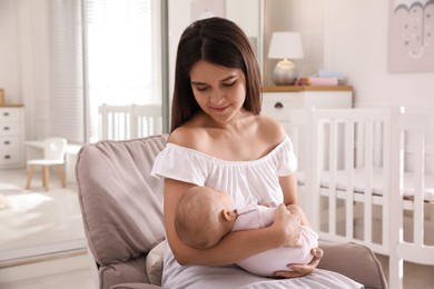 Photo of Happy young mother with her cute baby in armchair at home