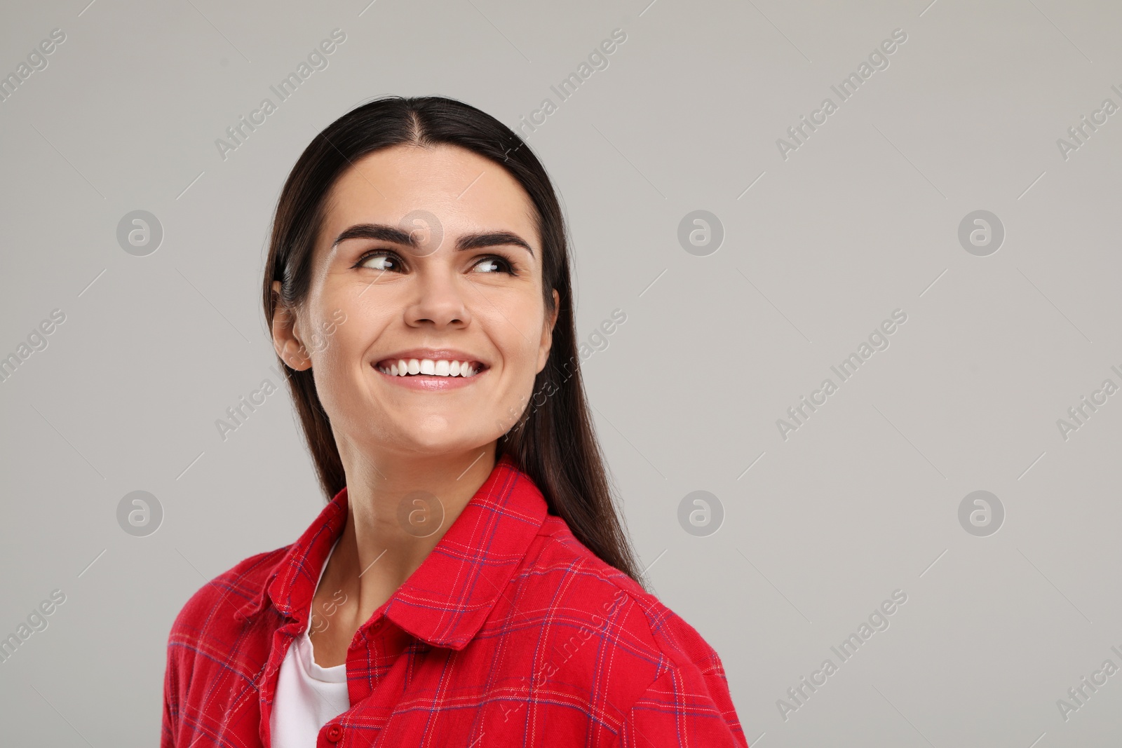 Photo of Young woman with clean teeth smiling on light grey background. Space for text