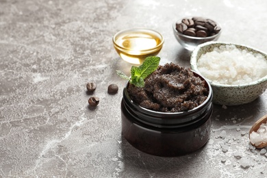 Jar with handmade natural body scrub and ingredients on grey background