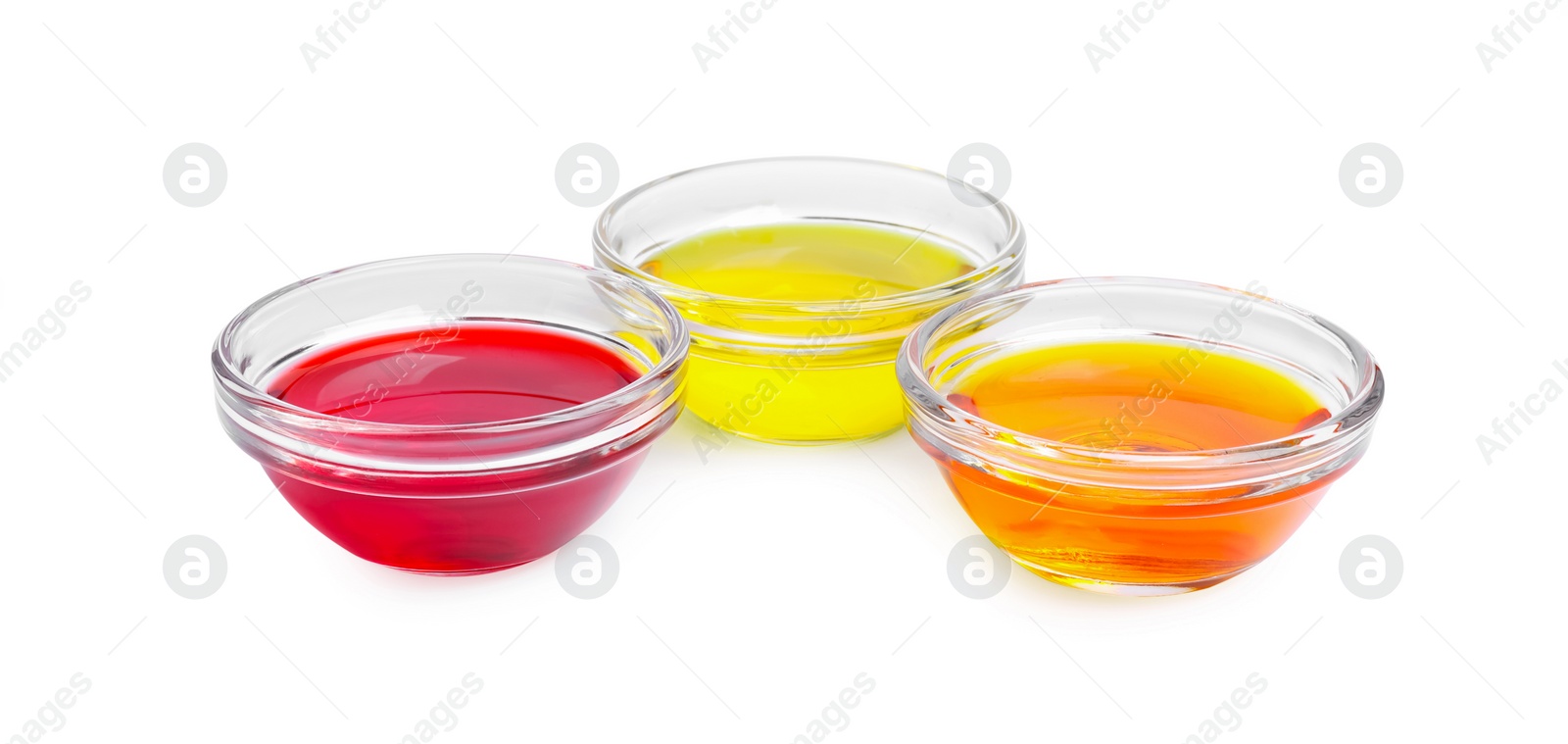 Photo of Glass bowls with different food coloring on white background