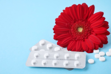 Photo of Many pills and flower on blue background, space for text. Gynecology concept