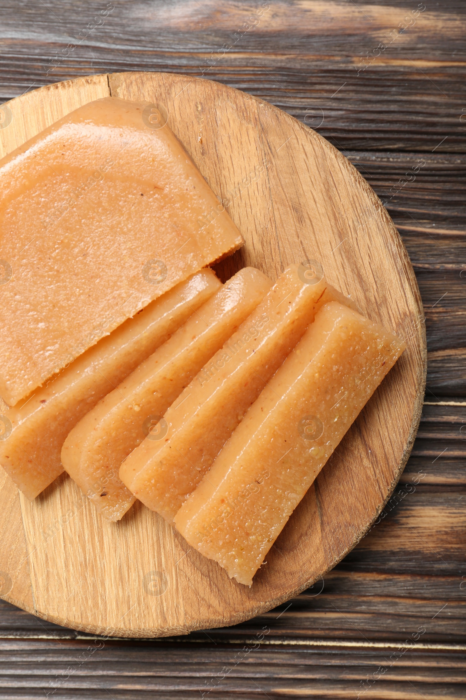 Photo of Tasty sweet quince paste on wooden table, top view