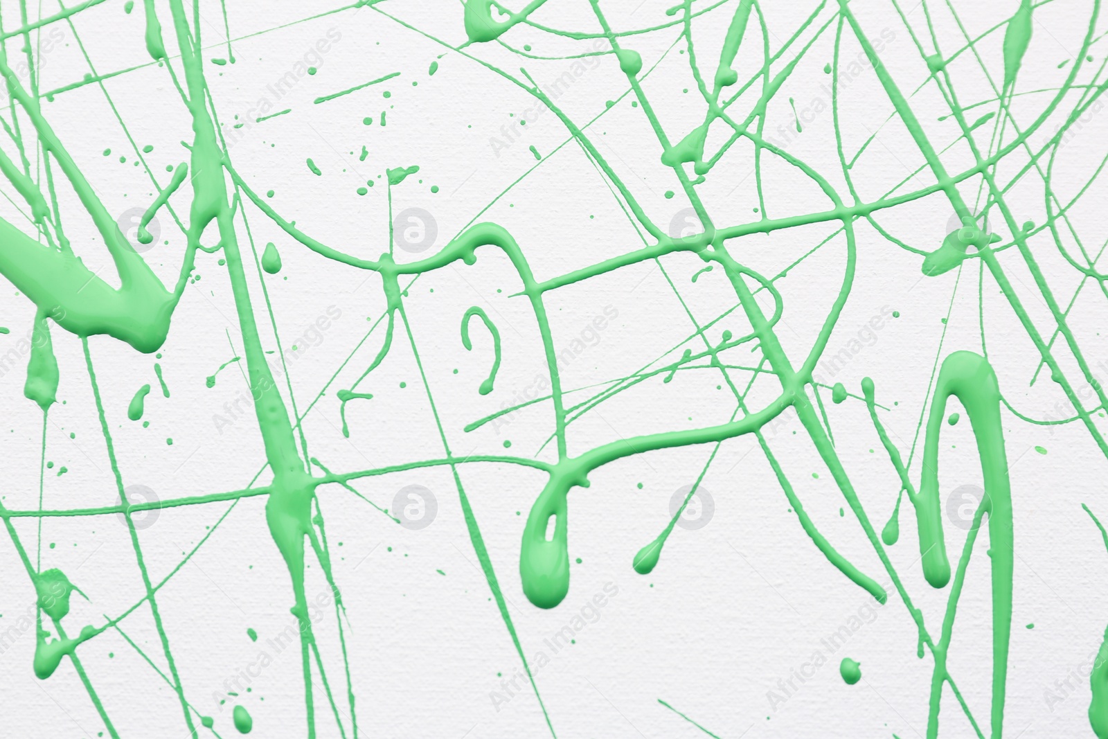 Photo of Green paint splashes on white canvas as background. Art and creativity