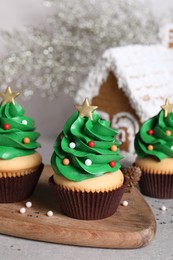 Photo of Christmas tree shaped cupcakes on light grey table