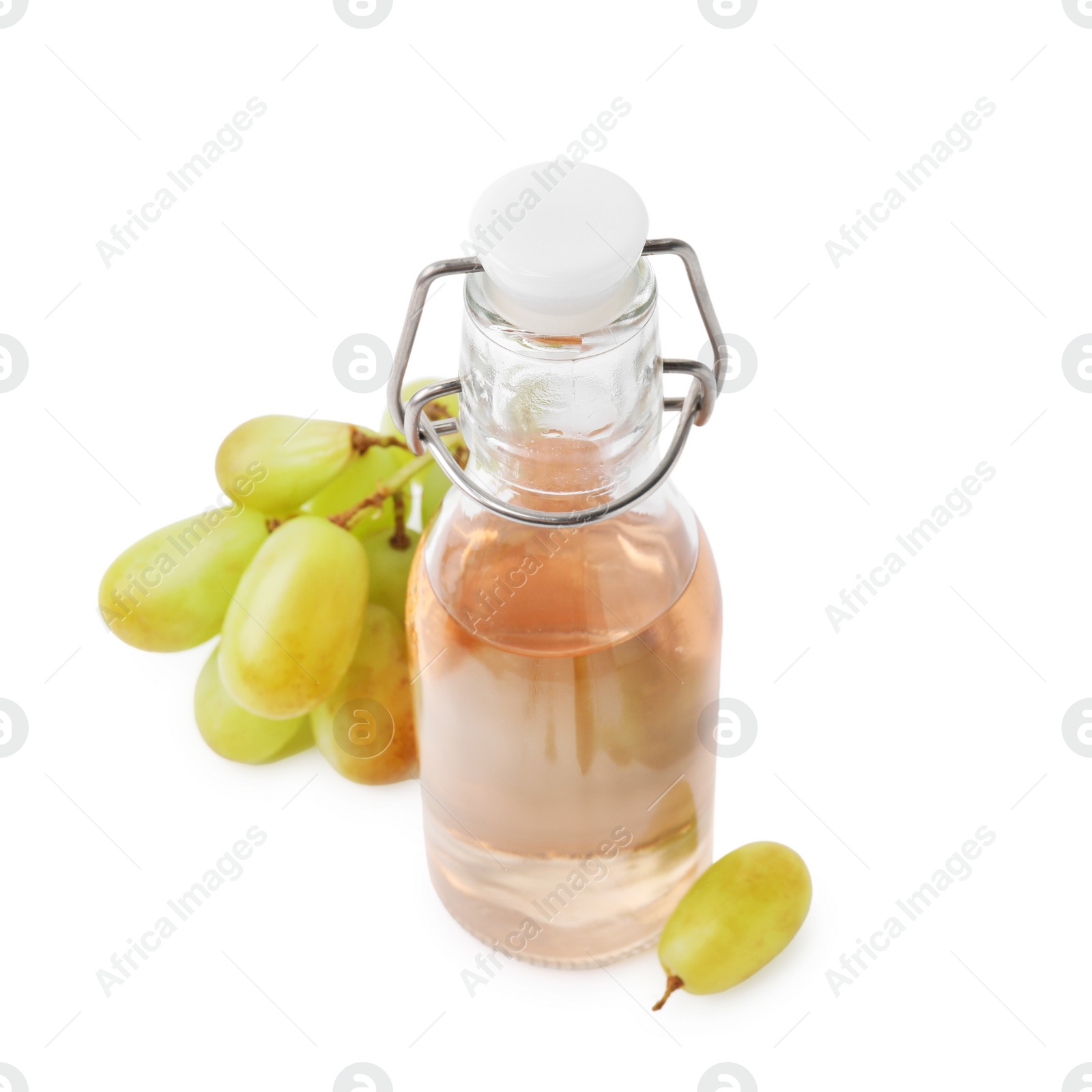 Photo of Grape vinegar in bottle and berries isolated on white